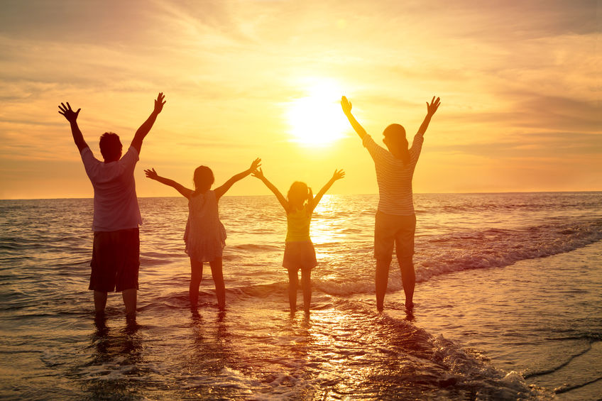 happy family watching the sunset on the beach happy family watching the sunset on the beach