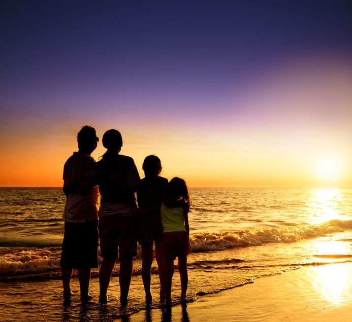 happy family watching the sunset on the beach